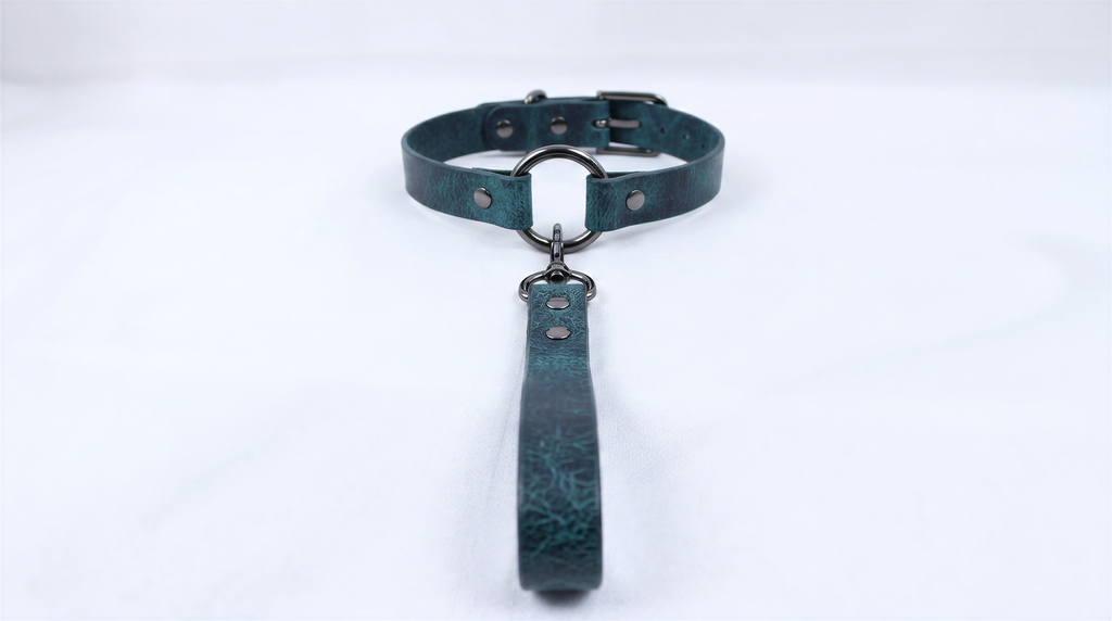 A dark green leather collar with a metal buckle and a handle attached to it.