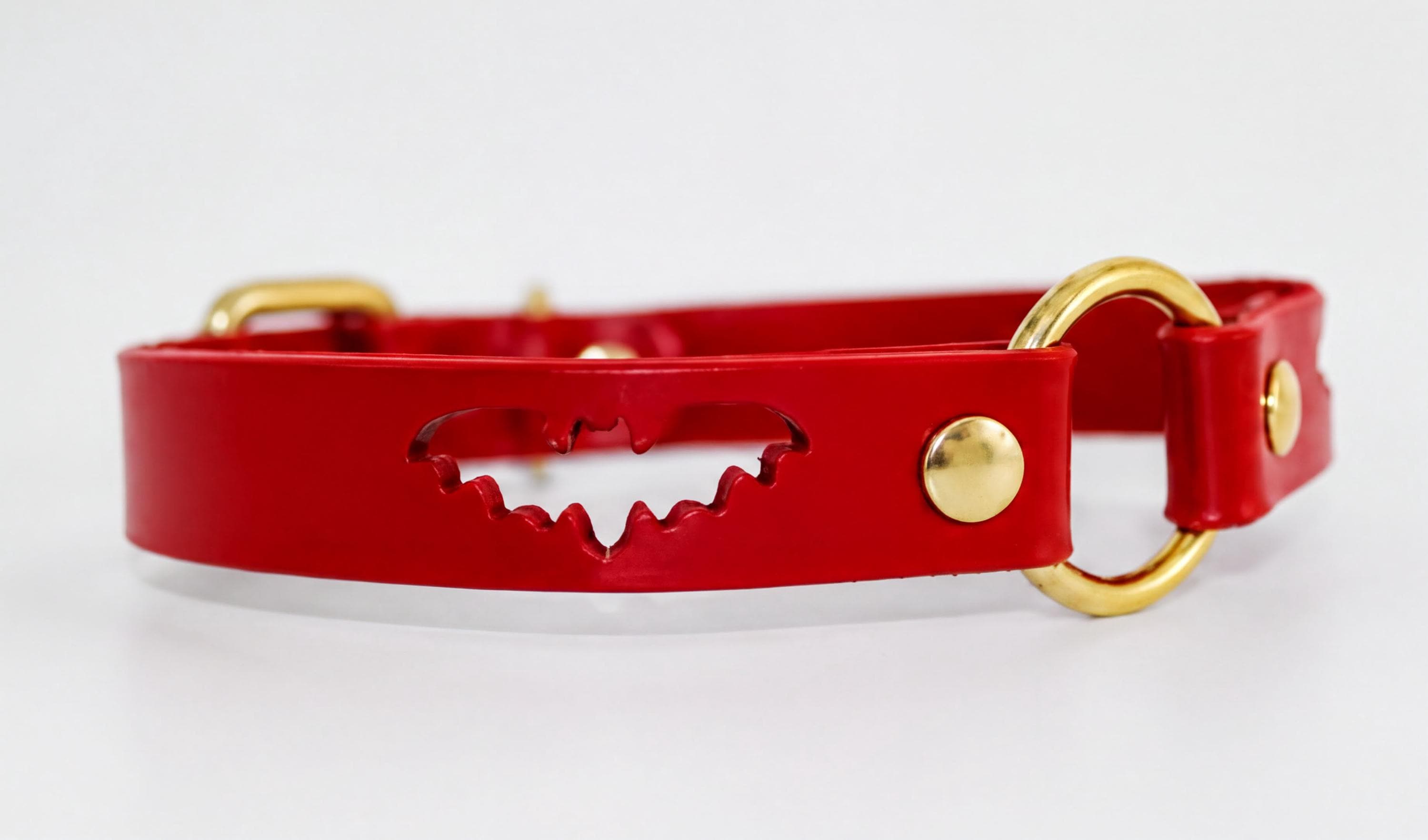 A red leather collar with a bat-shaped cutout in the center.