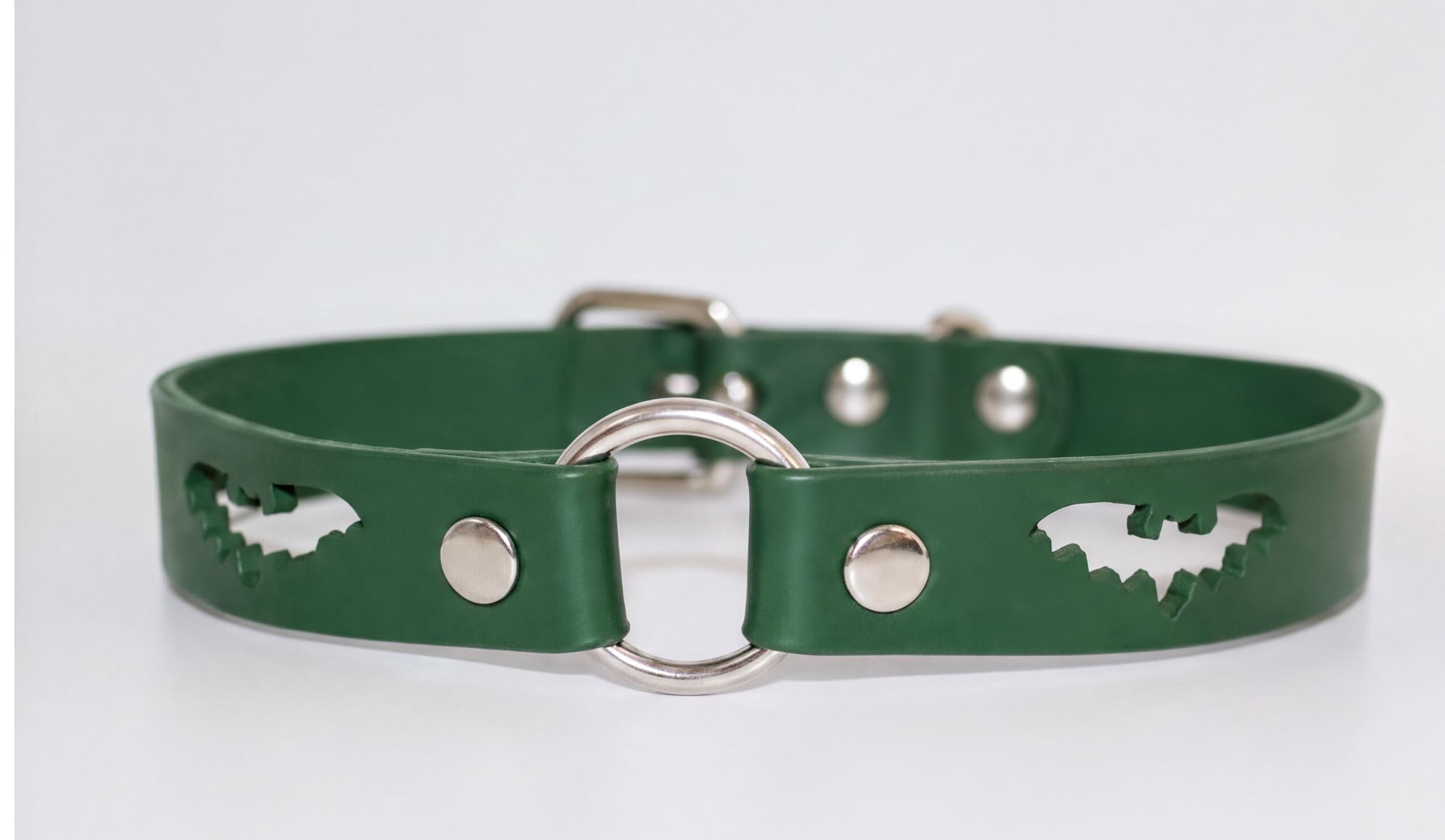 A green leather dog collar with a silver metal ring and cutout designs.