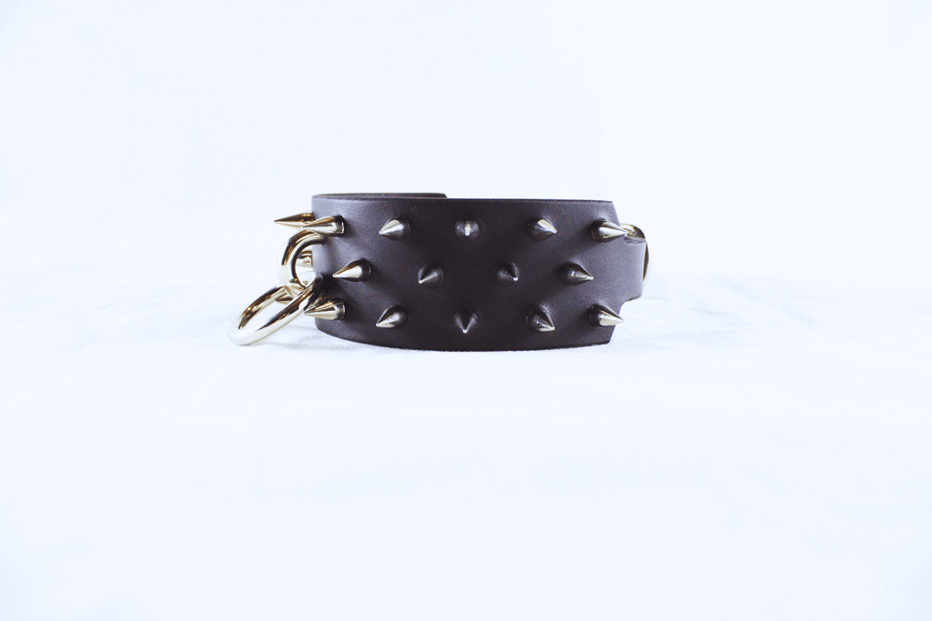 Dominion Leather Collar featuring polished spikes and a golden O-ring, showcasing gothic elegance and bold design.