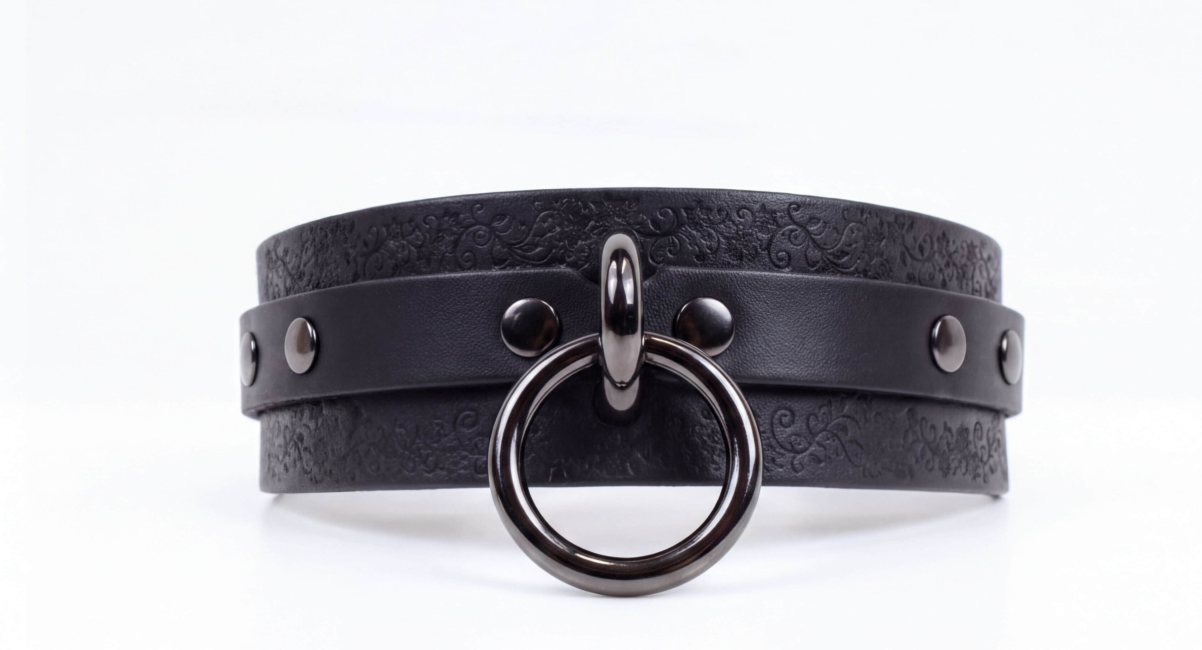 A black leather choker necklace with a metal ring and metal studs on the front.