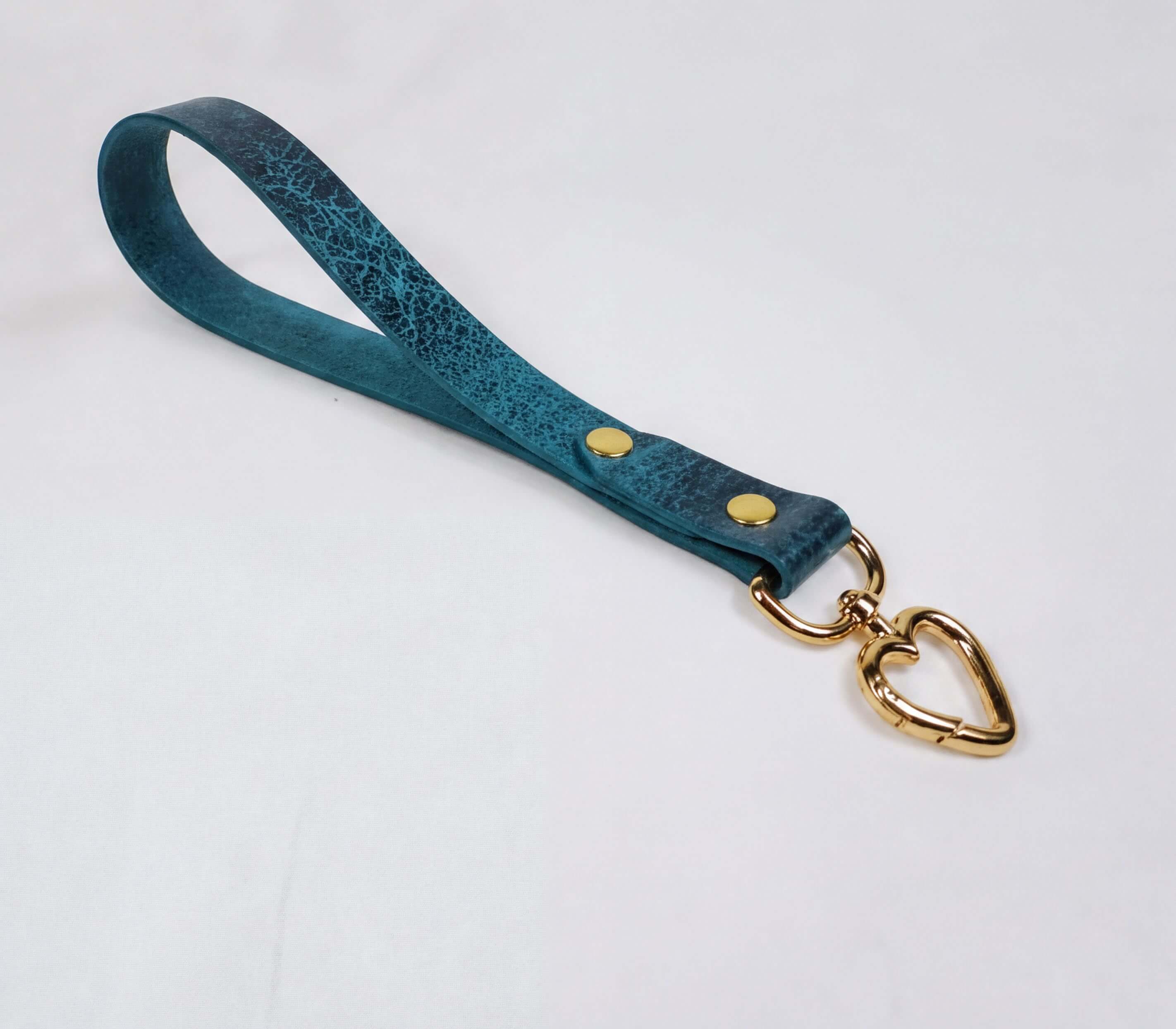 A blue leather strap with a heart-shaped metal clasp attached to it.