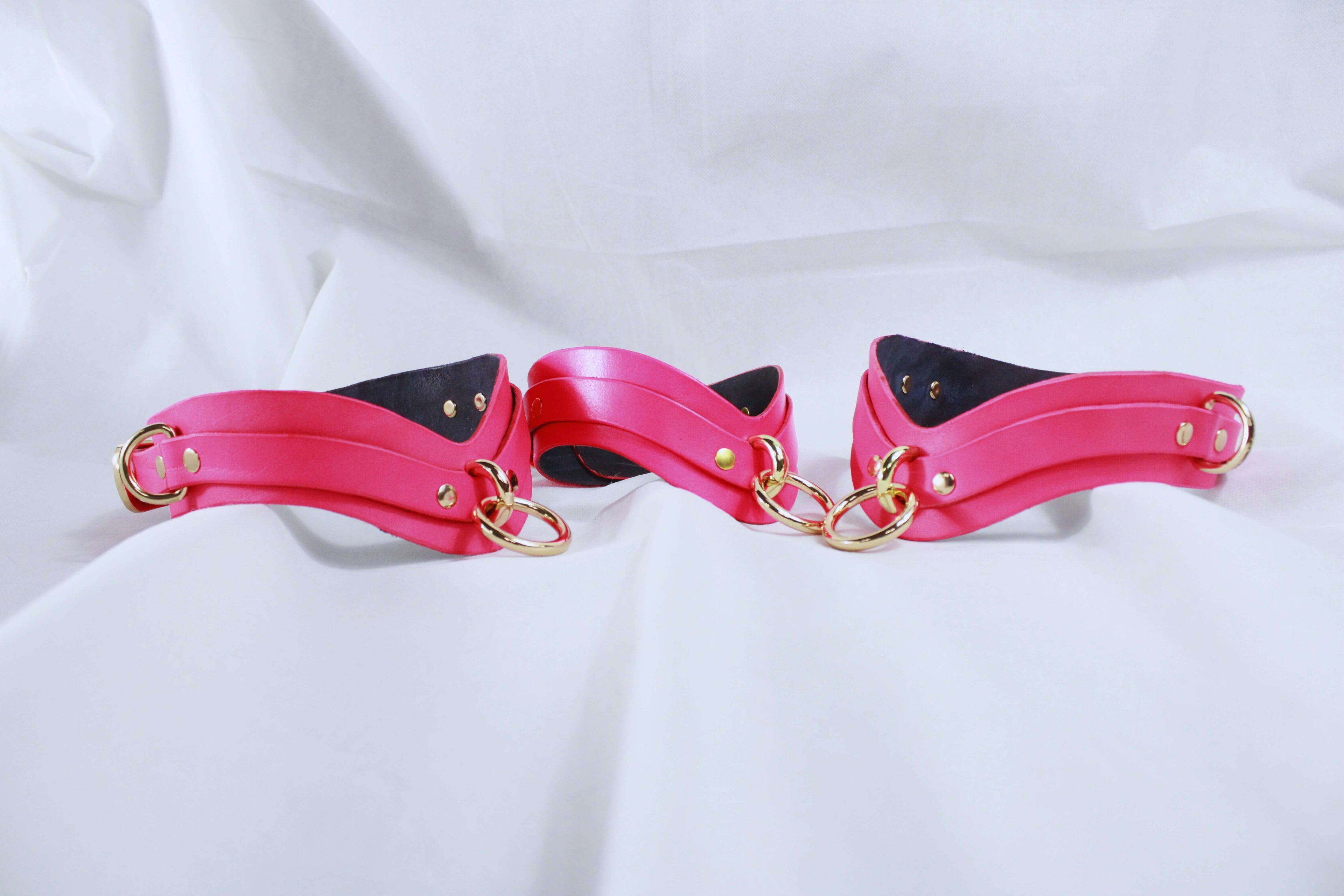 Elegant pink bondage cuffs featuring gold rings, ideal for submissive play and enhancing BDSM experiences.