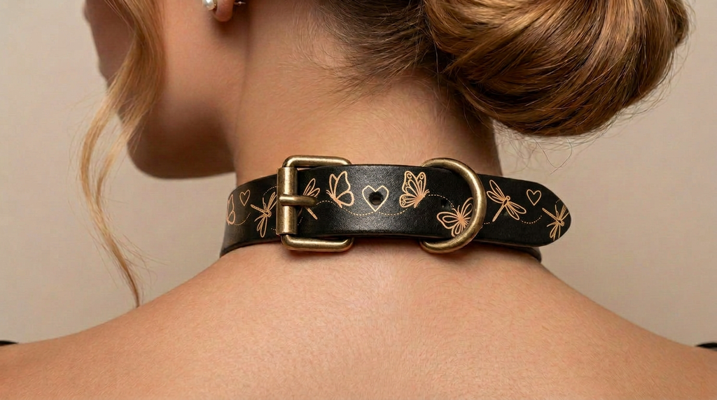A close-up view of a woman's neck and shoulders, focusing on a black leather choker necklace with a gold-colored buckle adorned with butterflies and hearts.