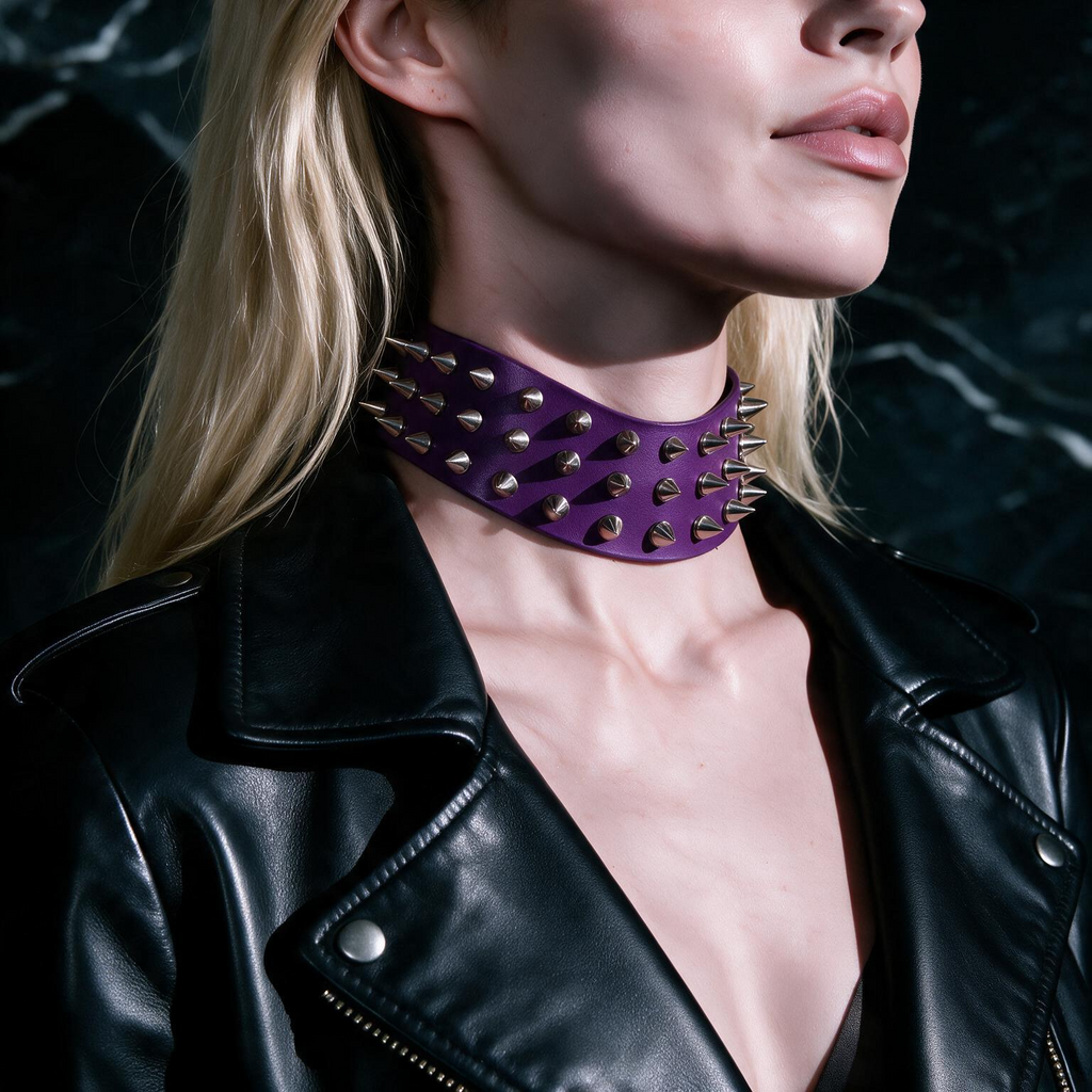 A close-up of a person wearing a black leather jacket with a purple choker necklace featuring spikes.
