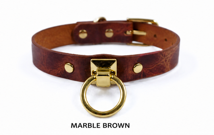 A brown leather collar with a gold-colored metal ring and buckle.