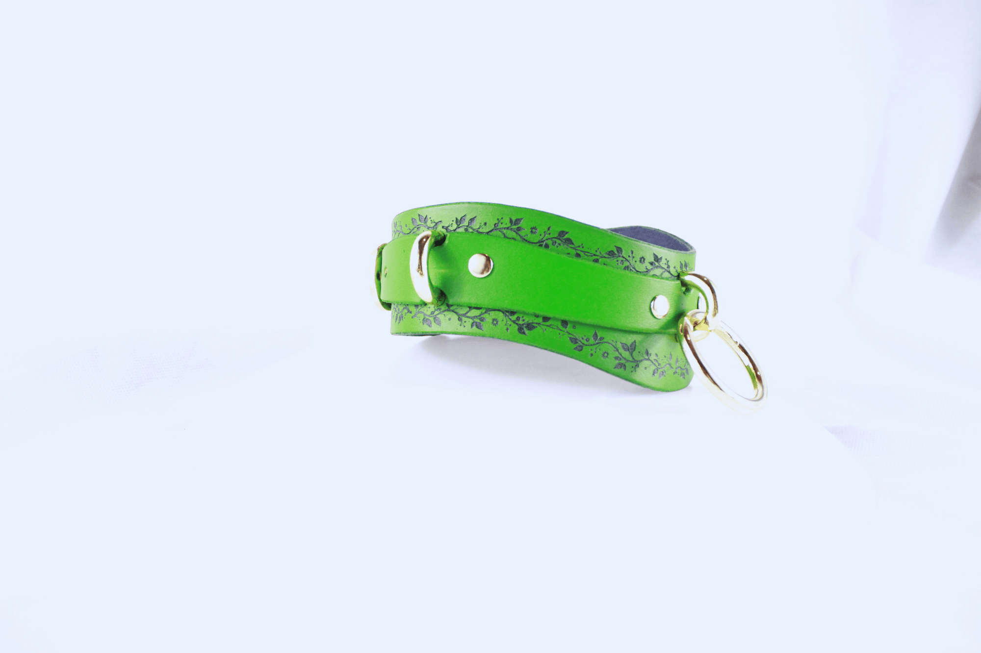 Green Vine Leather Submissive Collar featuring a delicate black vine pattern and polished rings.