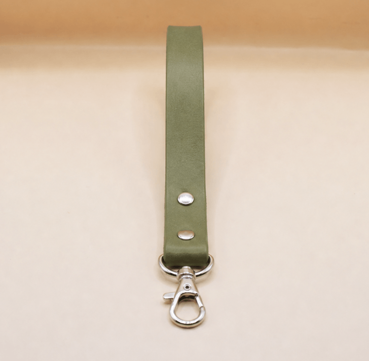 A green leather strap with a metal clasp and hook attached to it.