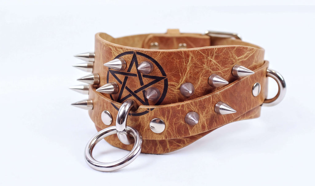 A leather choker necklace with spikes and a star-shaped emblem on the front.