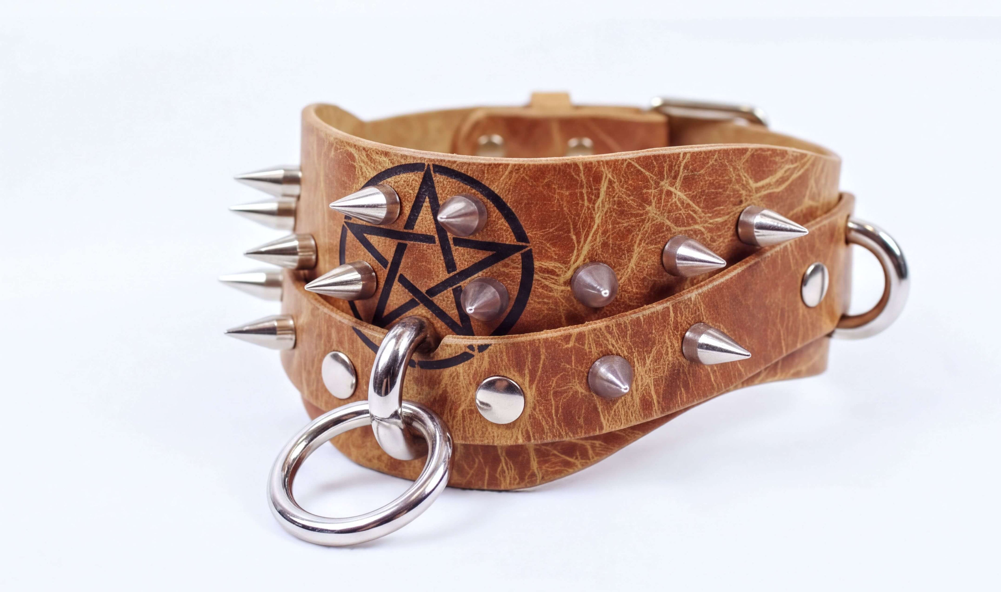 A leather choker necklace with spikes and a star-shaped emblem on the front.