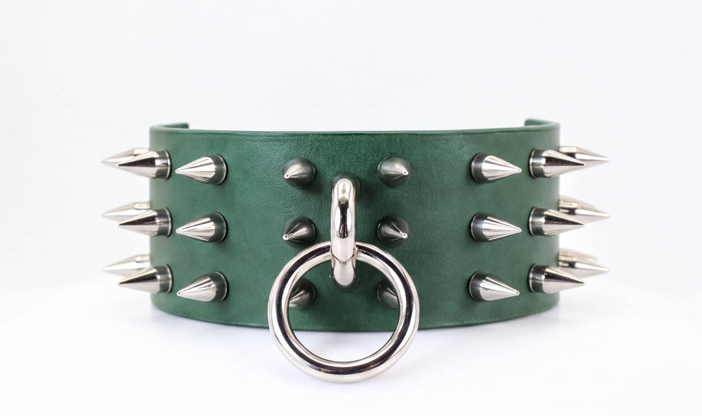 A green leather choker necklace with silver spikes protruding from it.
