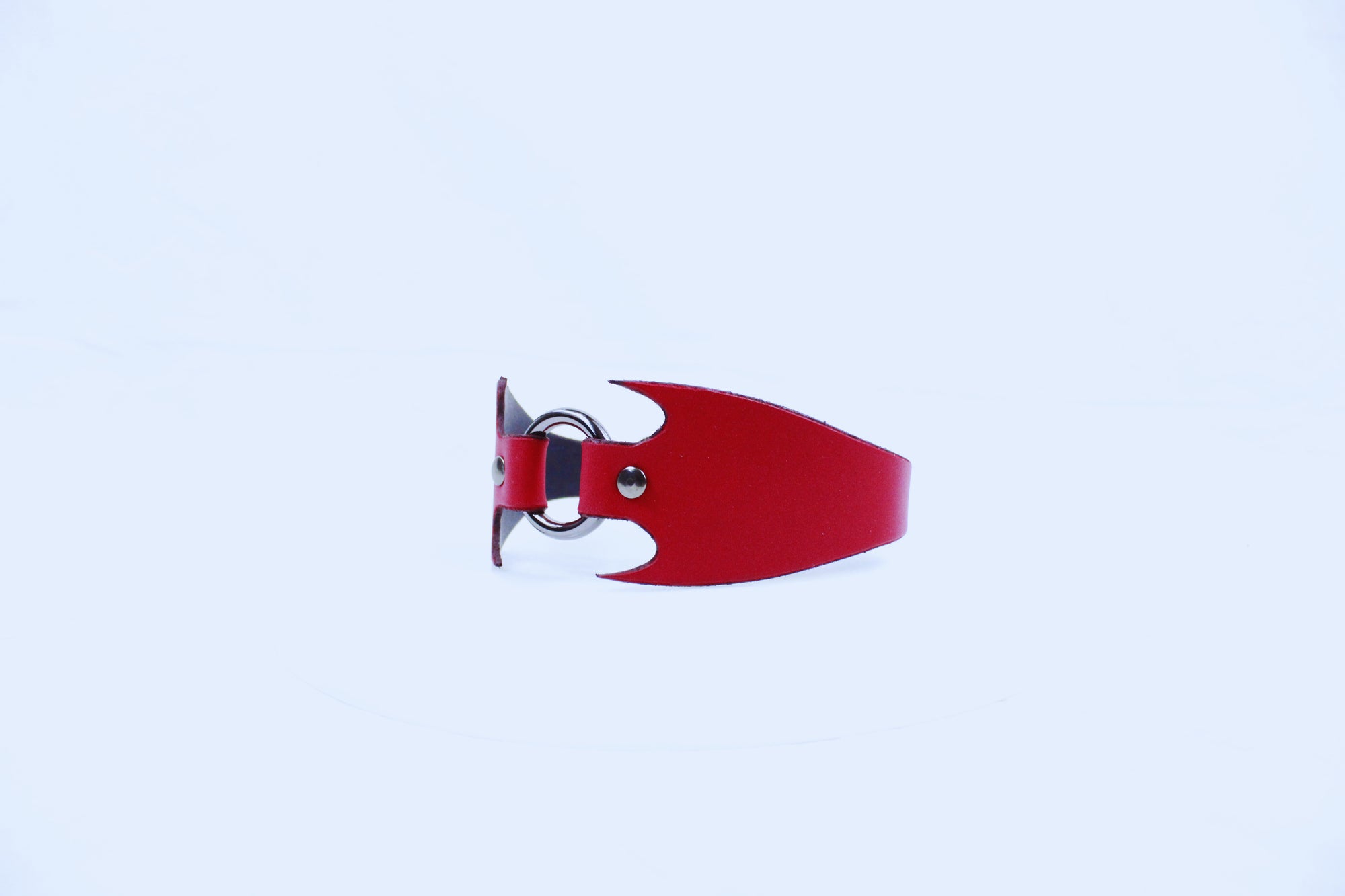 A red leather bracelet with a unique, pointed design is shown against a plain white background.