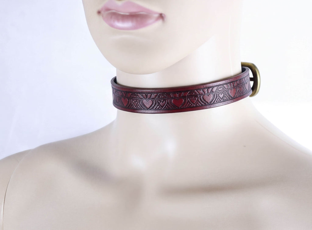A mannequin wearing a burgundy leather choker necklace with a heart-shaped design.
