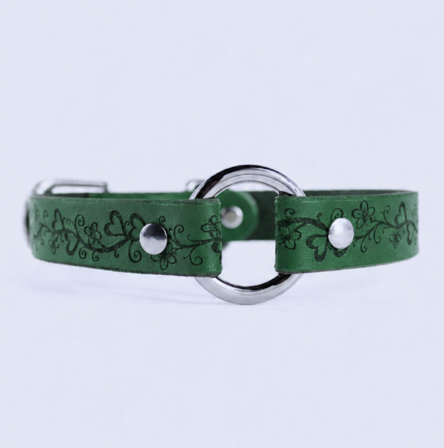 A green leather collar with a metal ring and decorative floral patterns.