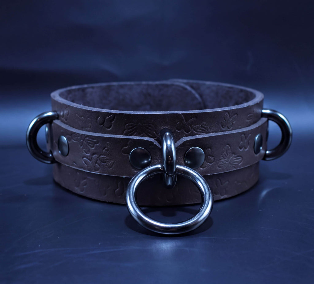 A brown leather choker necklace with metal rings and a metal clasp.