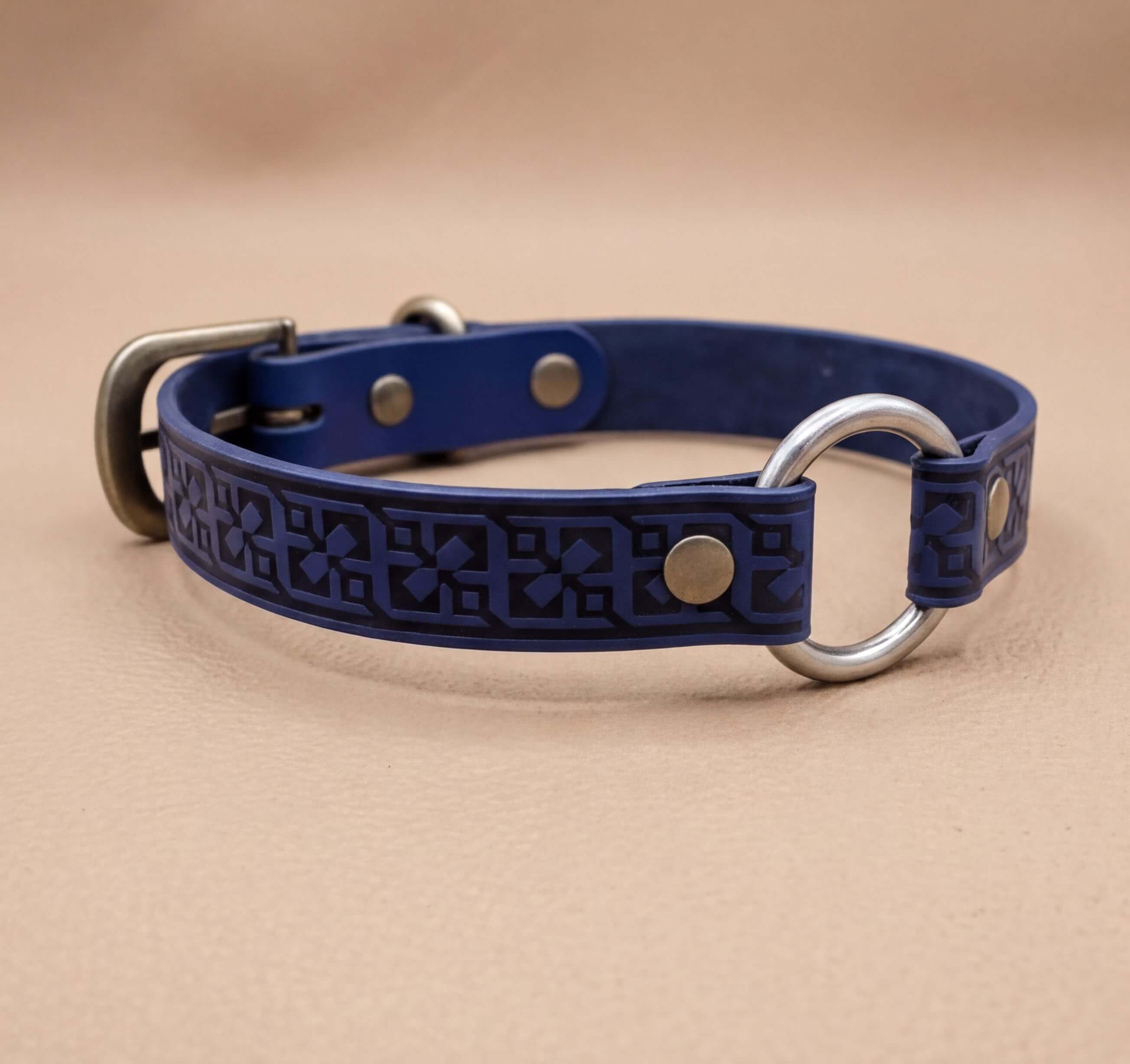 A blue leather dog collar with a metal ring and buckle.