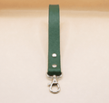 A green leather strap with a metal clasp and hook attached to it.