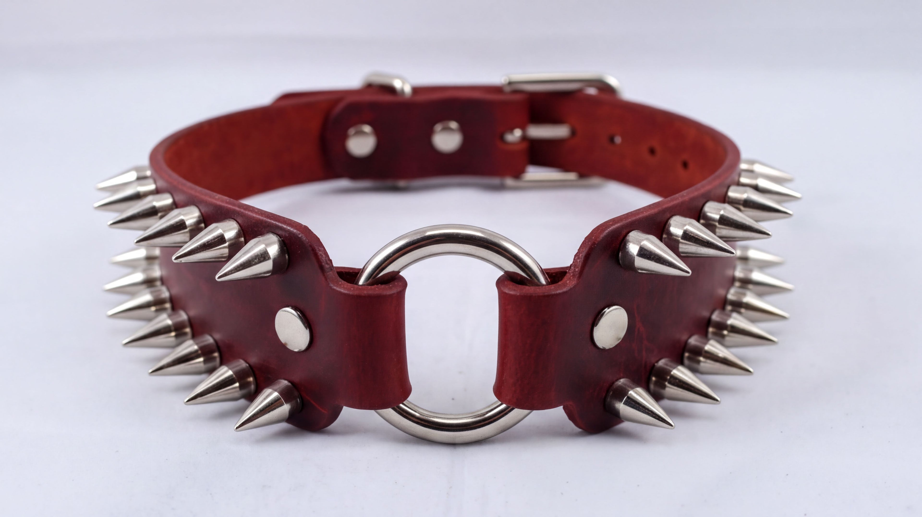 A red leather choker necklace with spikes protruding from it.