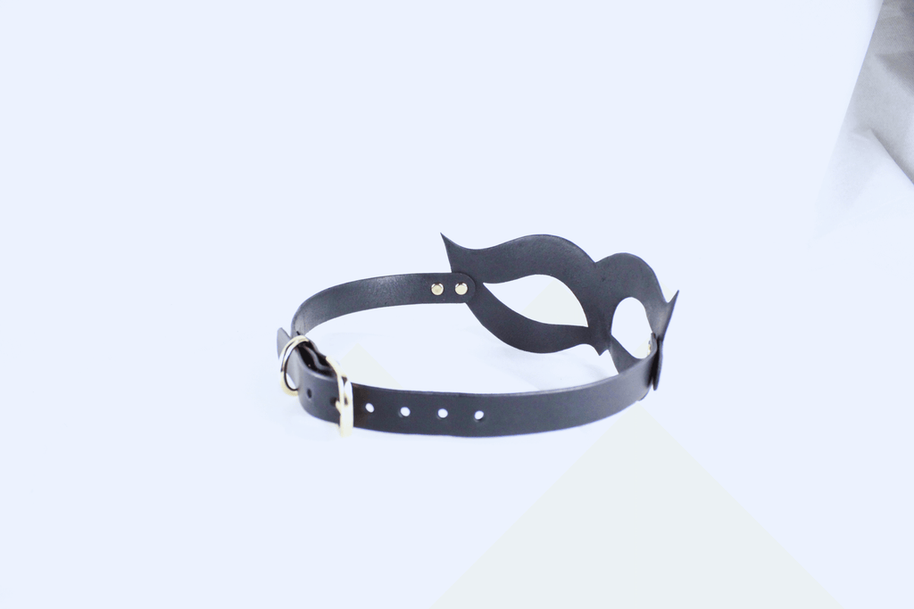 A black leather choker necklace with a unique, abstract design.