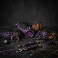 a collection of black leather accessories with intricate designs, including a choker, cuffs, and straps, all adorned with purple and pink accents.