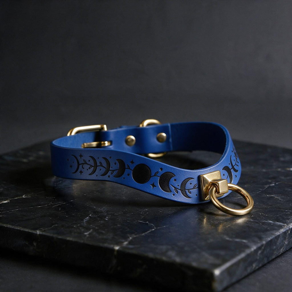 A blue leather choker necklace with a moon and star motif, featuring a gold-colored metal ring and buckle.