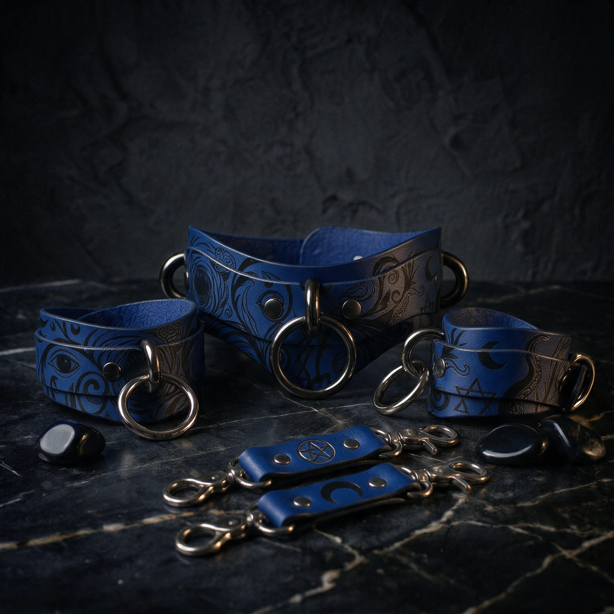 A collection of blue leather straps with metal rings and buckles, arranged on a dark surface.