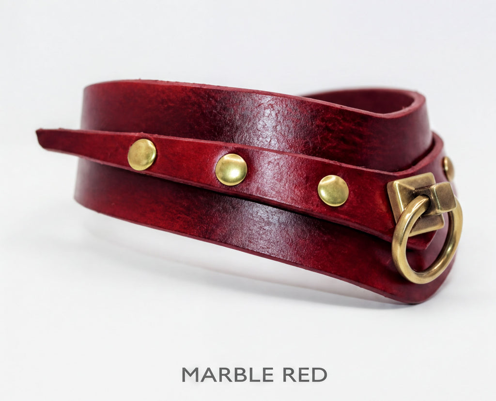 A red leather choker necklace with brass hardware and three brass buttons.