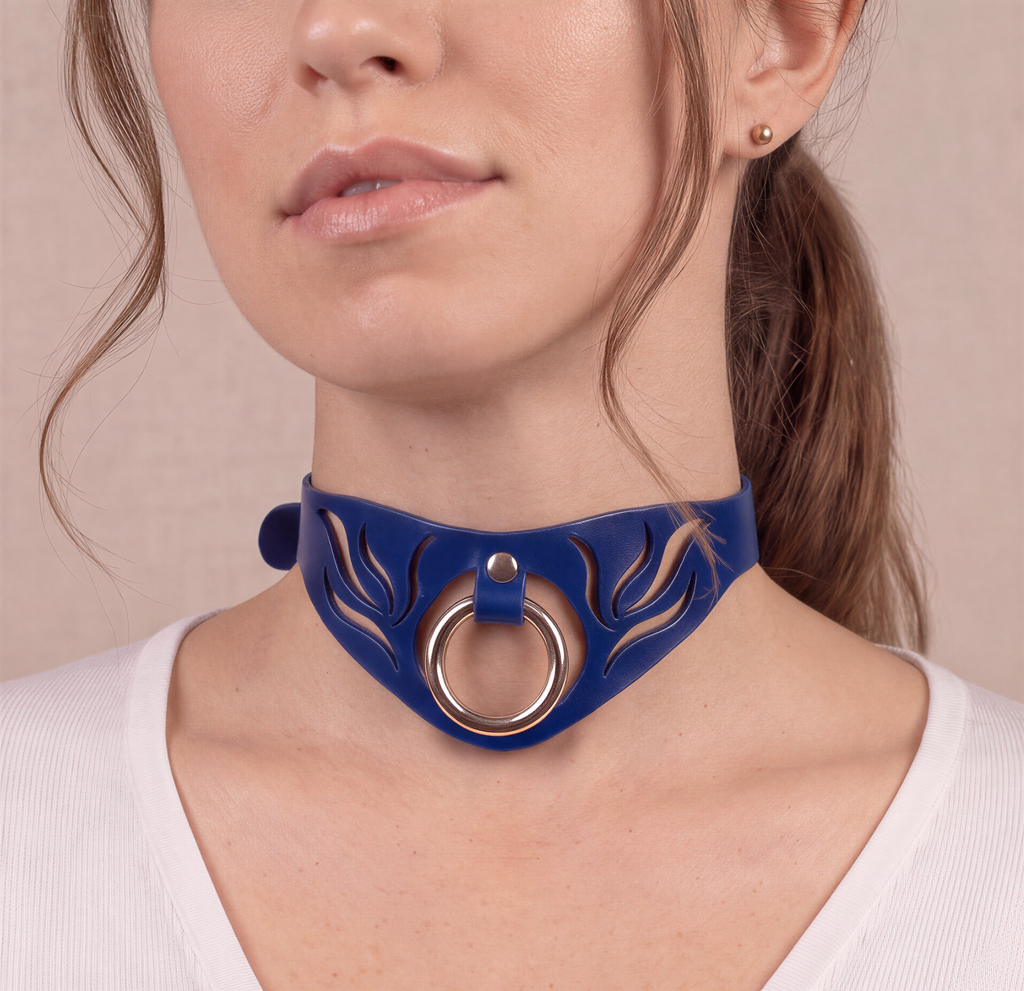 A close-up of a woman's face wearing a blue choker necklace with a silver ring.