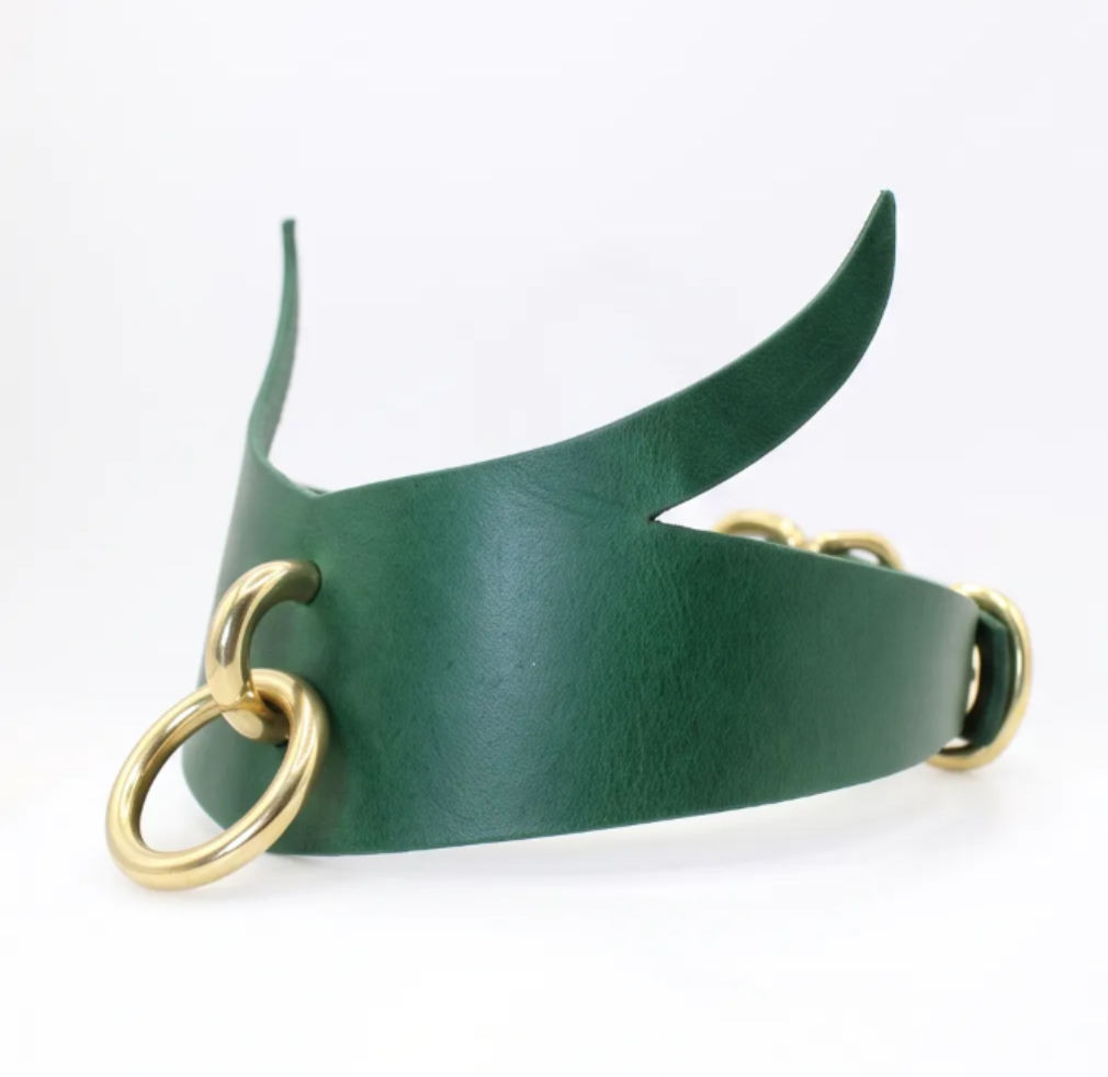 four leather choker necklaces with different colors and designs, including purple, green, black, and silver rings.
