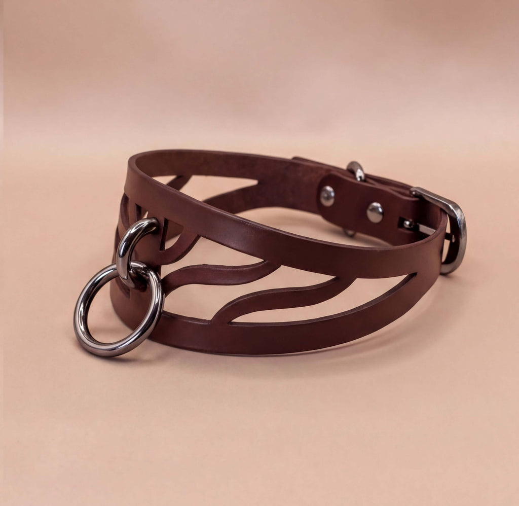 A brown leather choker necklace with metal rings and a buckle.