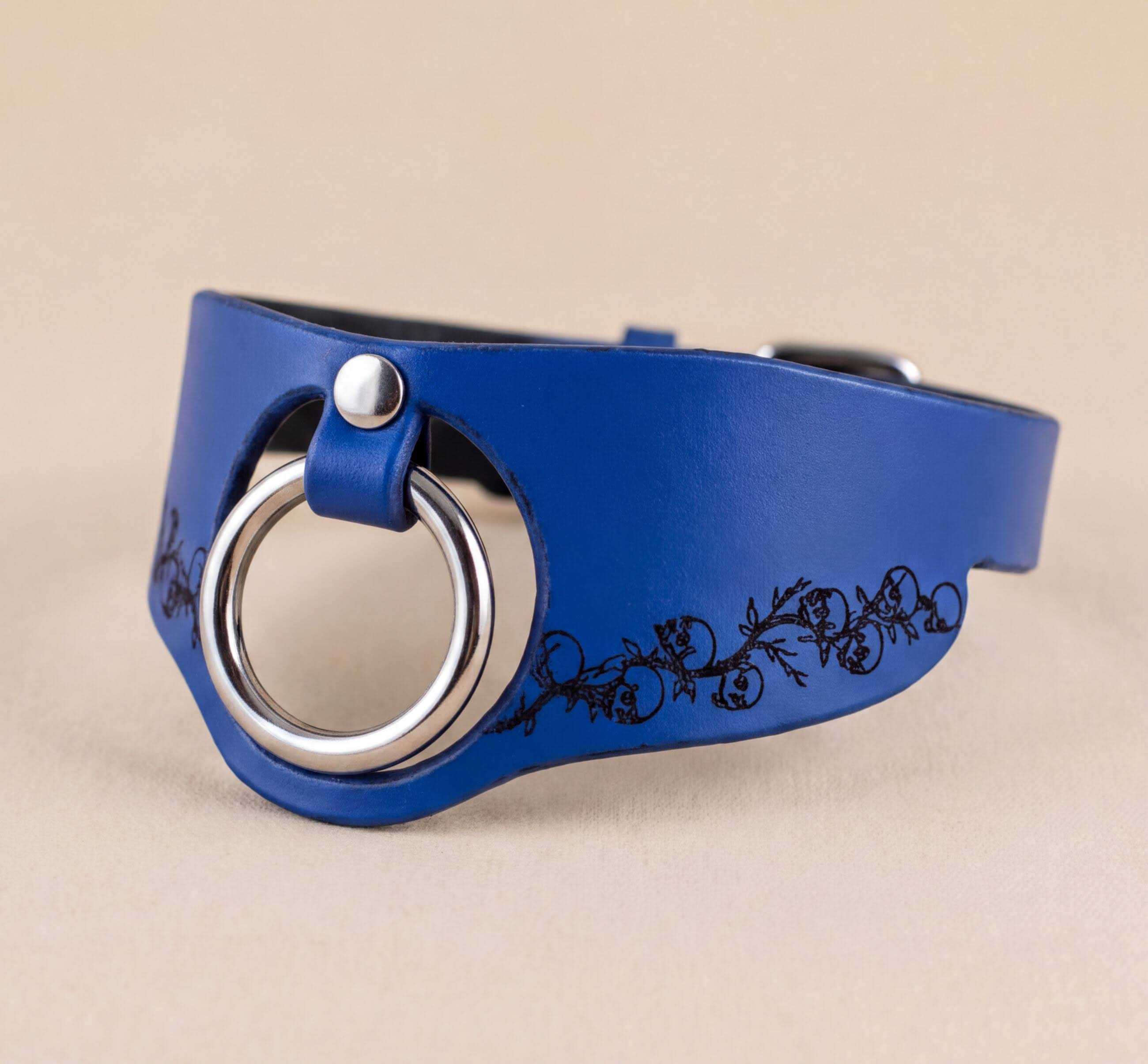 A blue leather choker necklace with a silver ring and floral design on the side.
