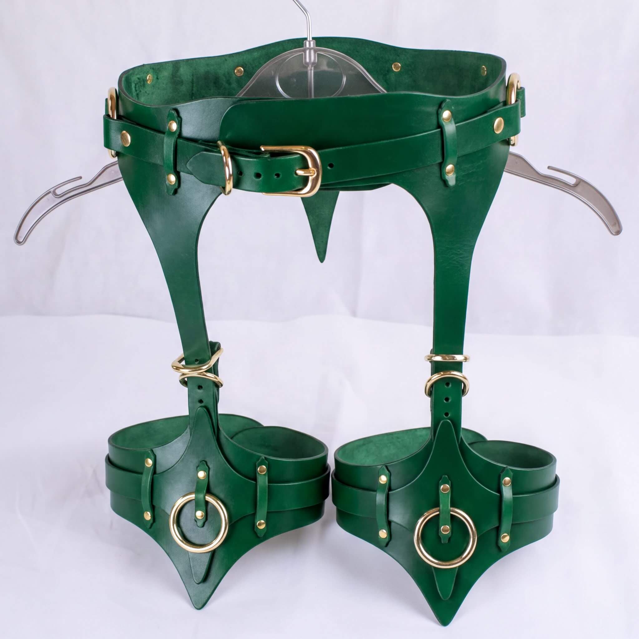 A pair of green leather thigh-high boots with a unique design and multiple buckles and straps.