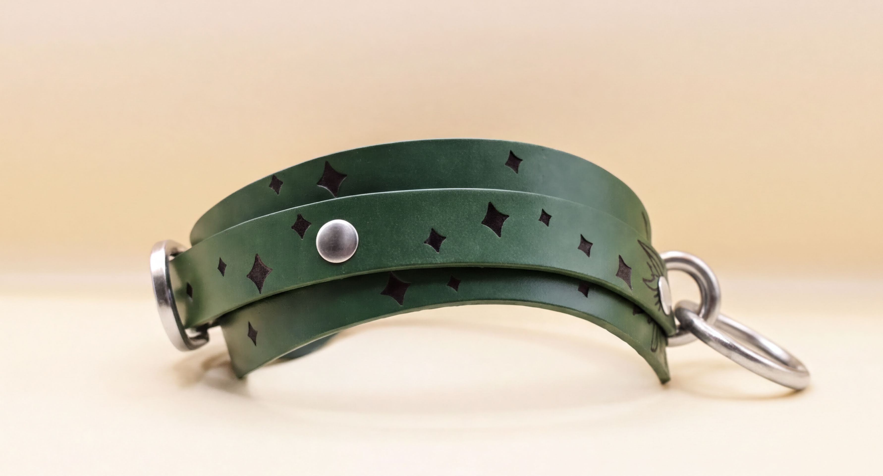 A green leather choker necklace with a silver metal clasp and a star-shaped embellishment on the front.