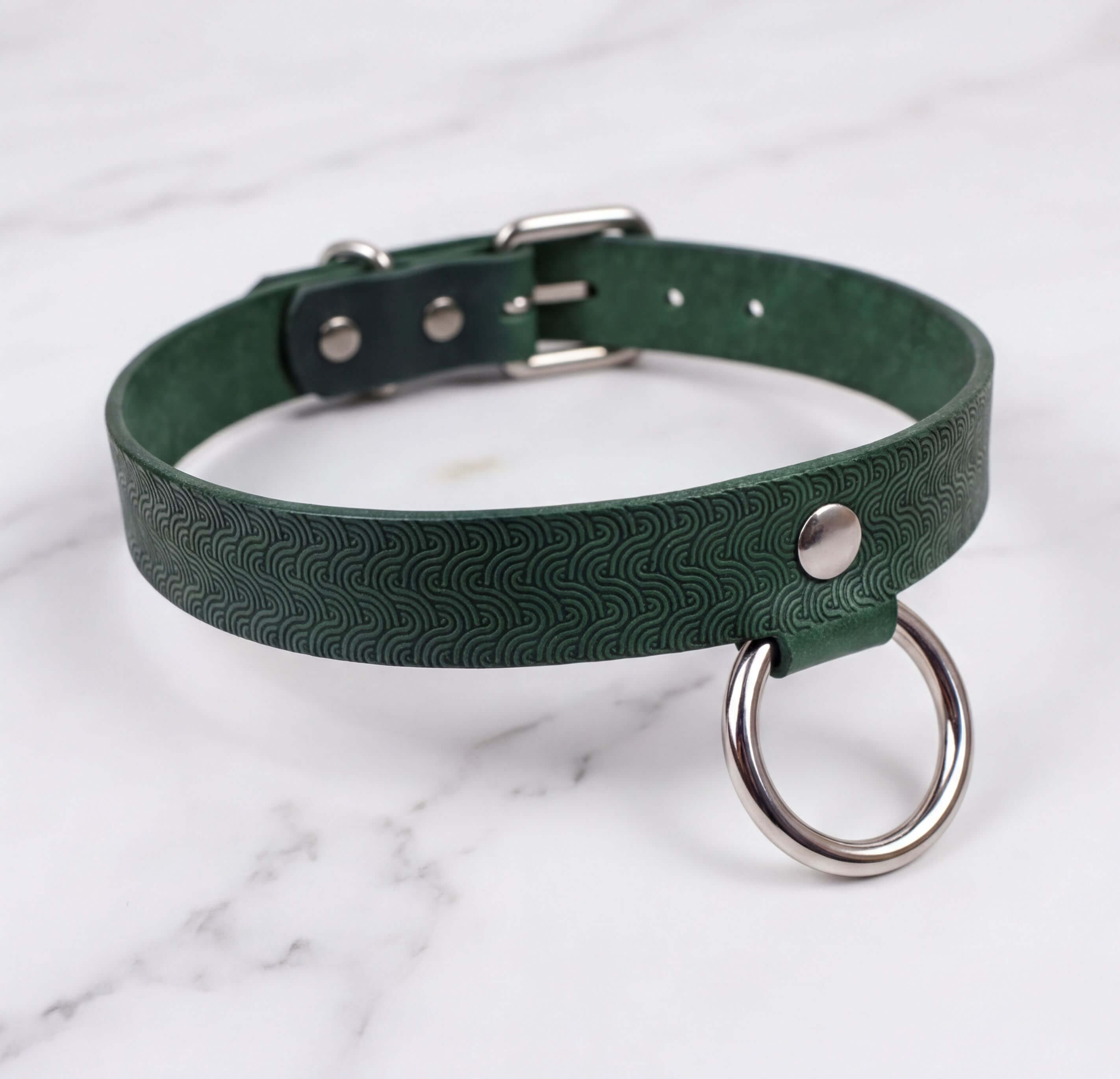 A green leather choker collar with a metal ring and buckle.