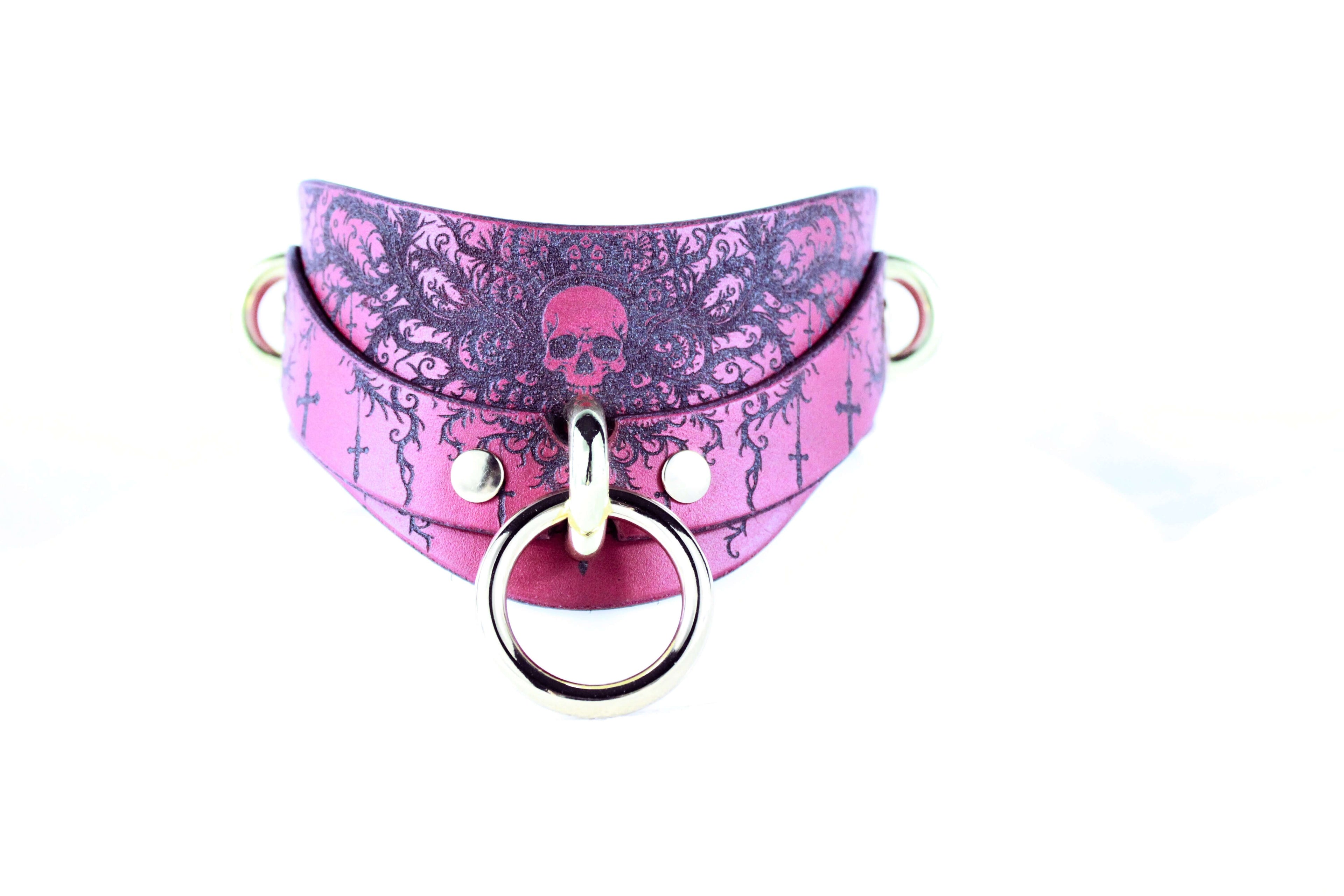 Gothic Skull Posture Collar in pink leather with skull design and D-ring for BDSM style accessories.