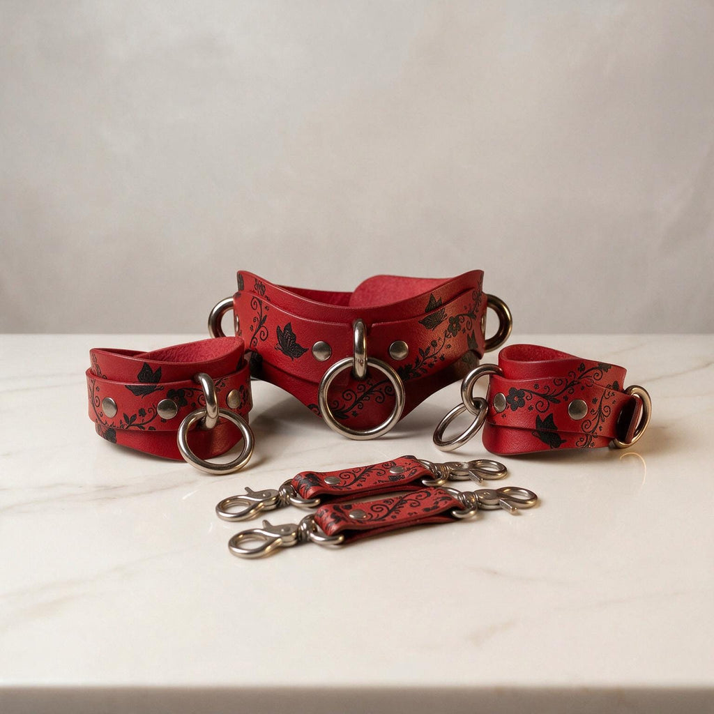 a collection of red leather straps with metal rings and buckles, arranged on a white marble surface.