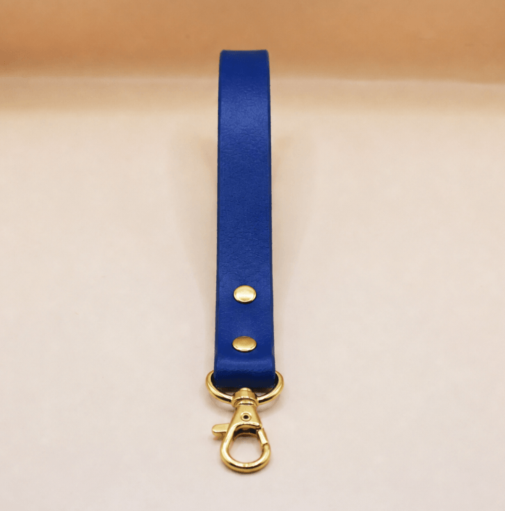 A blue leather strap with a gold metal clasp and hook is shown against a light background.