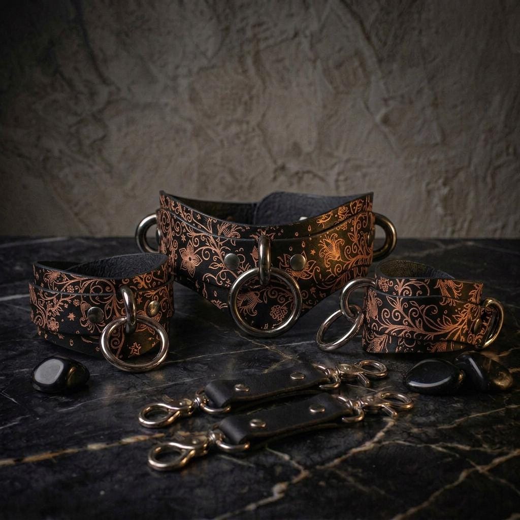 a collection of ornate leather straps and buckles, arranged on a dark surface.