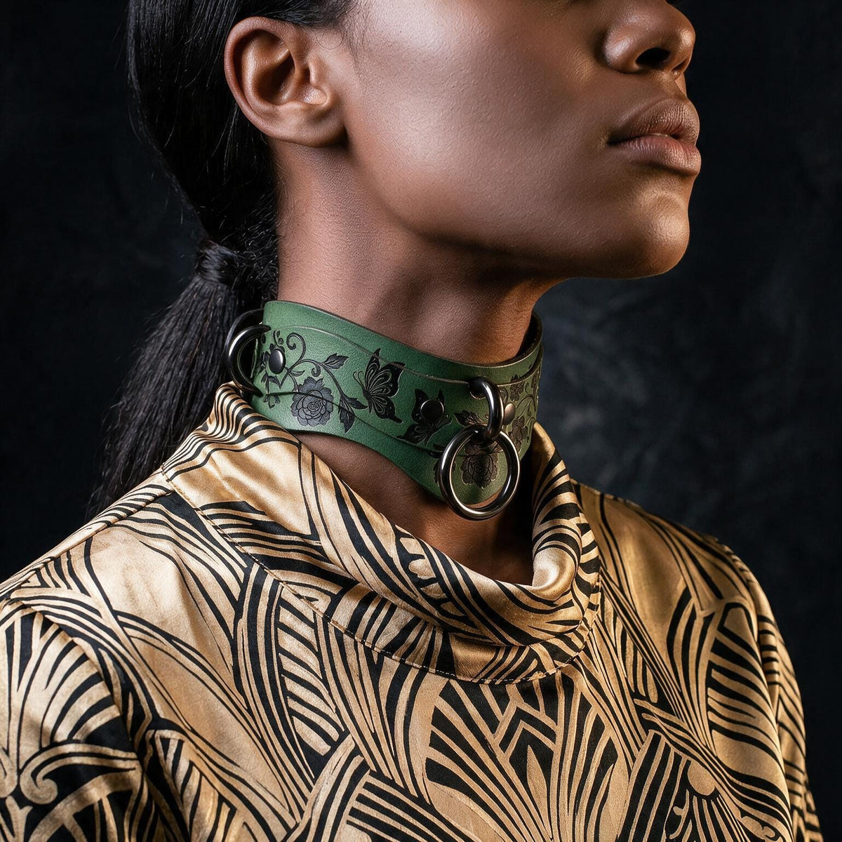A close-up of a woman's neck and chest area wearing a green choker necklace with a floral pattern.