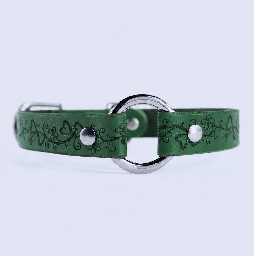 A green leather collar with a metal ring and decorative floral patterns.