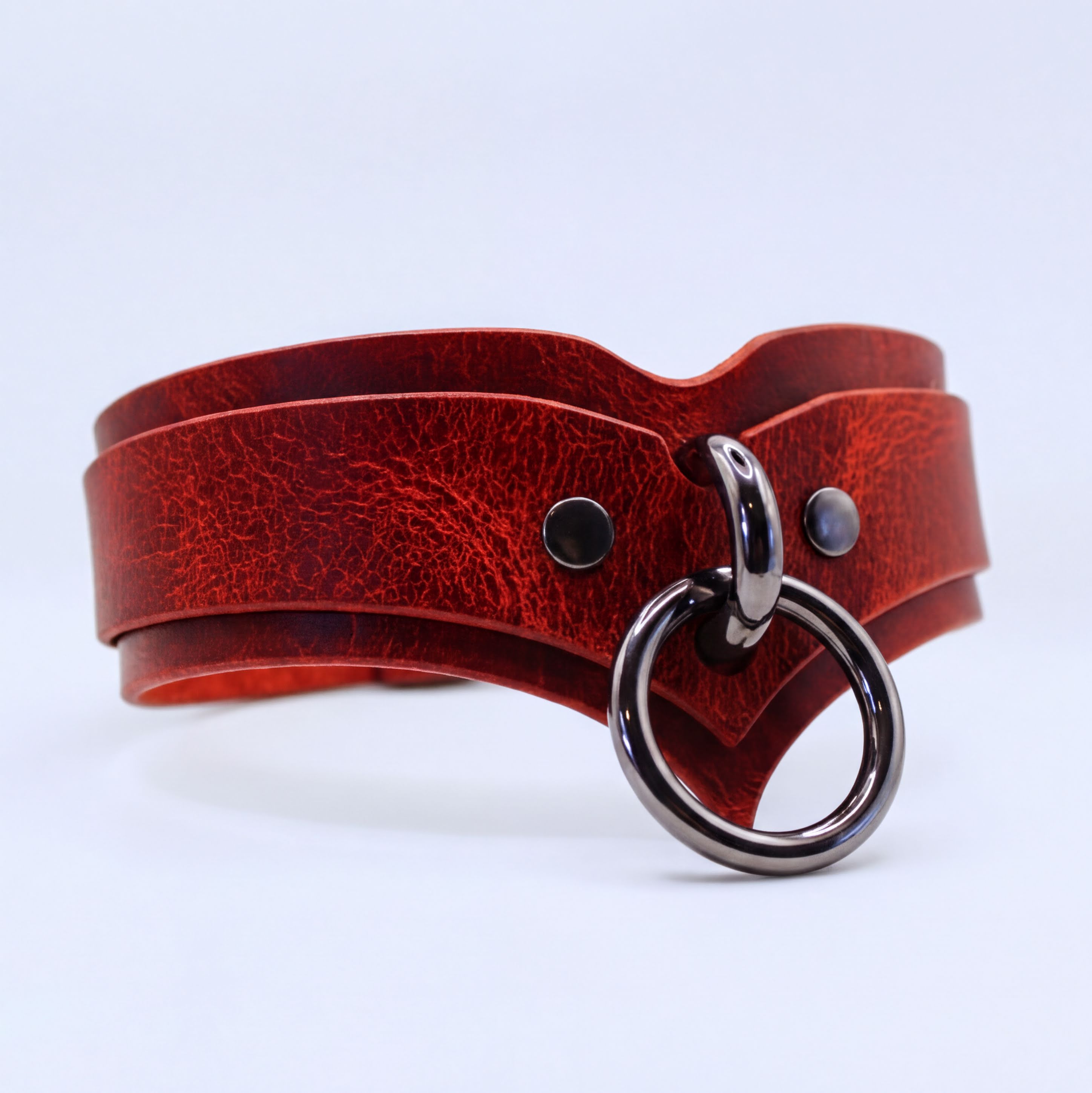 A red leather choker collar with a metal ring and buckle.