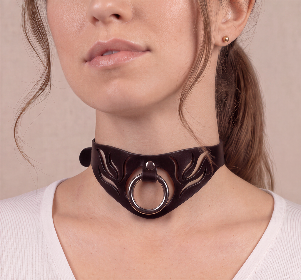 A close-up of a woman's face wearing a black choker necklace with a circular ring on the front.