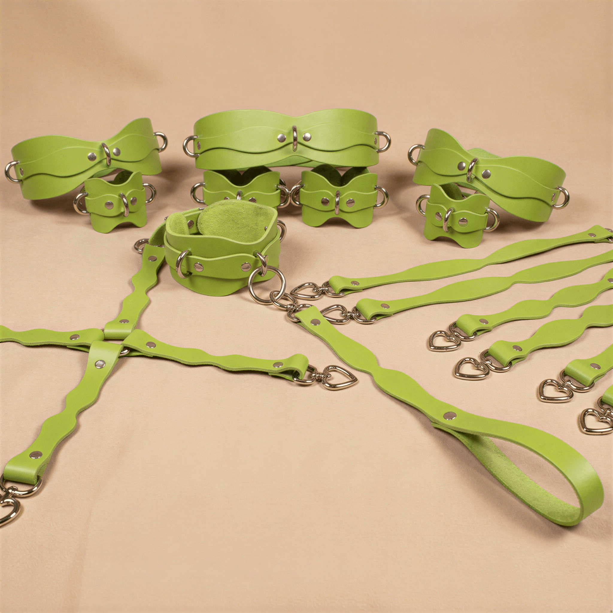 a collection of green leather straps and buckles arranged on a beige background.