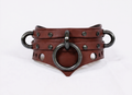A brown leather collar with metal rings and studs, featuring a distinctive design.