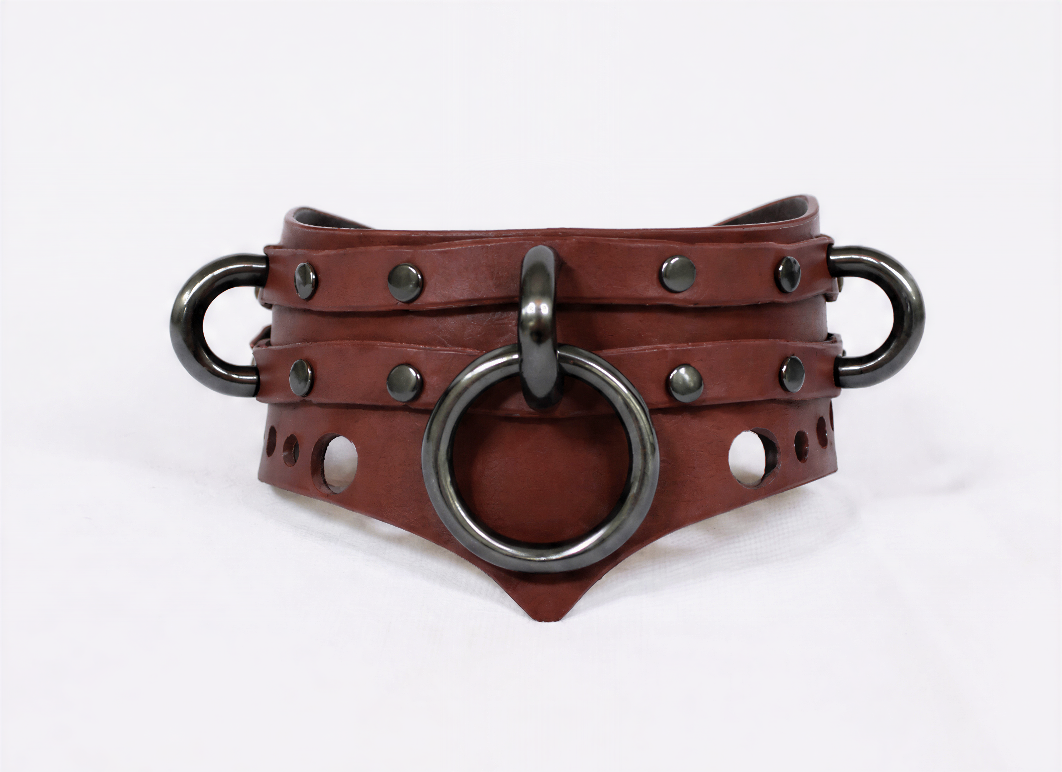 A brown leather collar with metal rings and studs, featuring a distinctive design.