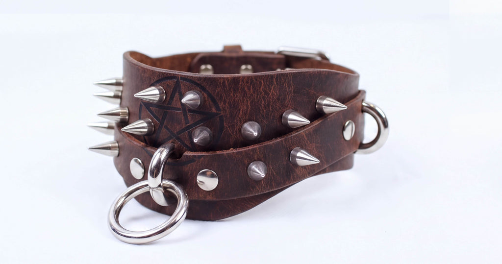 A brown leather choker bracelet with metal spikes and a metal ring.
