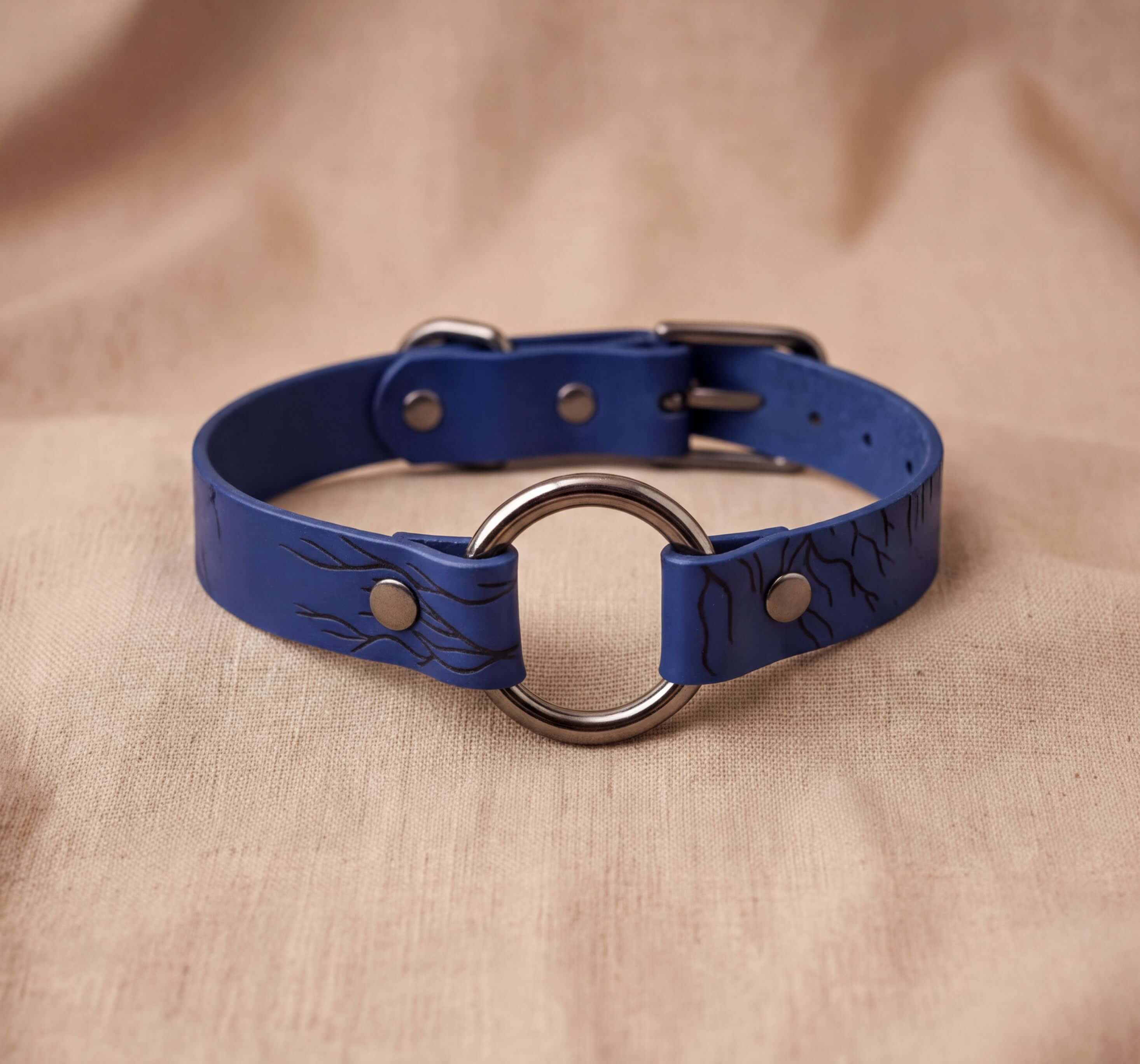 A blue leather choker collar with a metal ring and buckle.