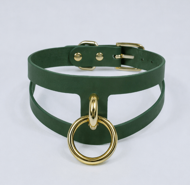 A green leather choker necklace with a gold-colored metal ring attached to it.