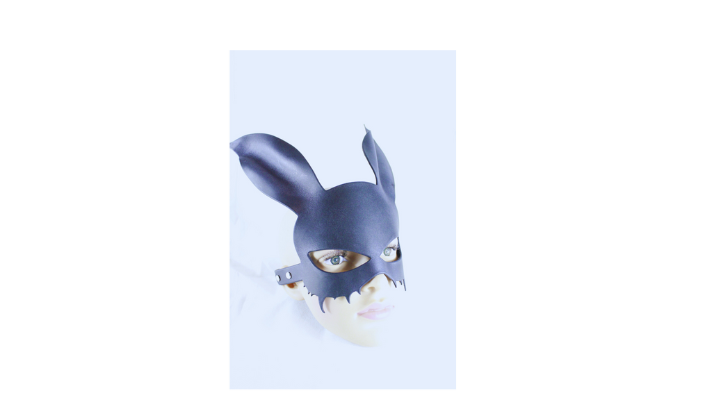 A person wearing a black mask with large ears, resembling a rabbit or a cat-like creature.