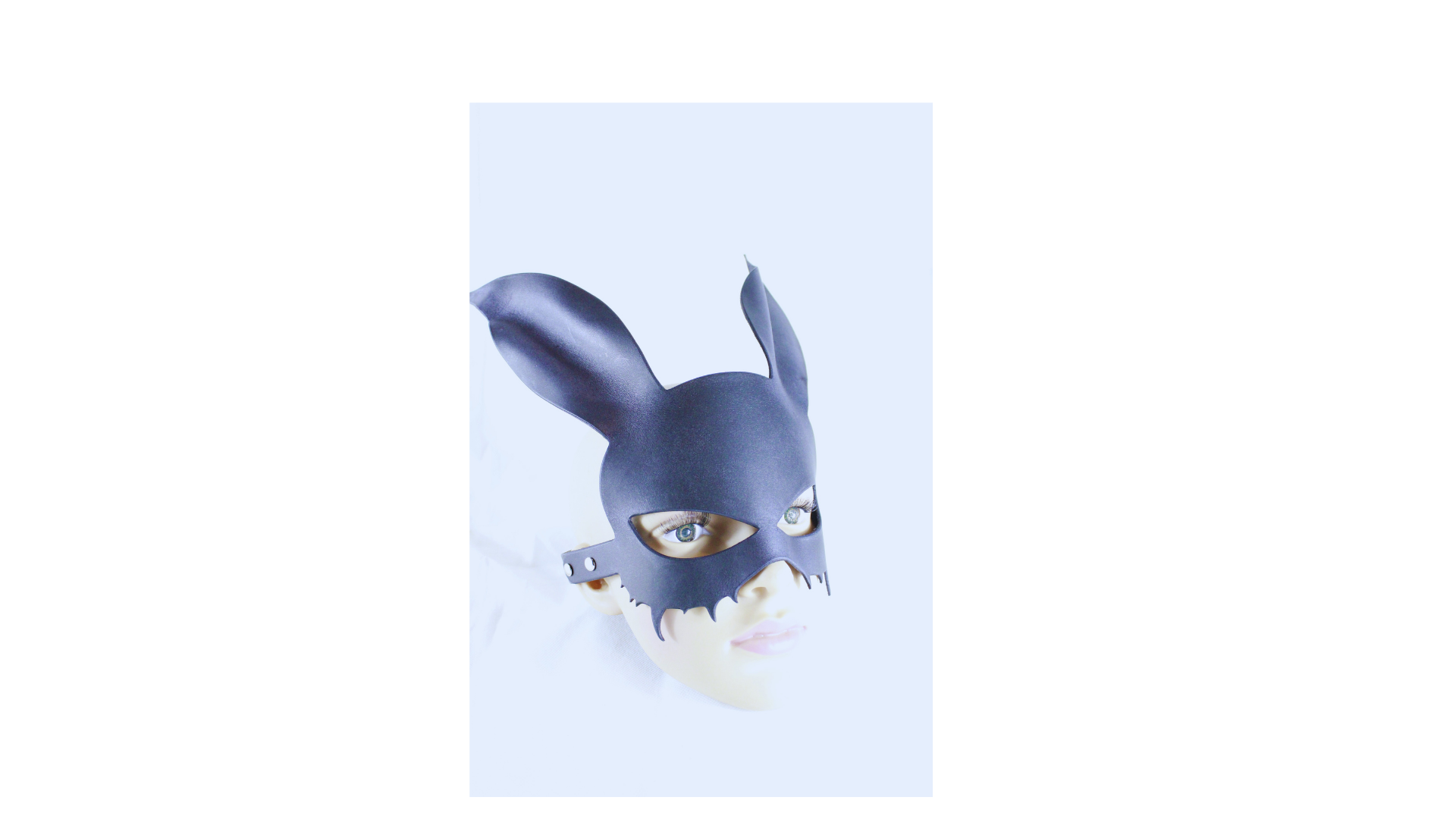 A person wearing a black mask with large ears, resembling a rabbit or a cat-like creature.